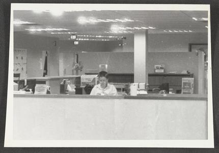 Library staff member at work behind circulation desk