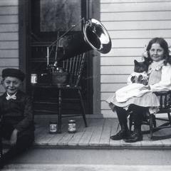 Edgar and Jennie Krueger on the front porch with “Tramp” the cat
