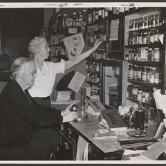 Two pharmacists work behind the prescription counter