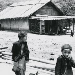 Two Yao (Iu Mien) boys are in front of a family dwelling in a village in the area of the town of Vang Vieng in Vientaine Province