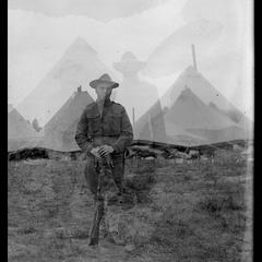 Soldier in front of camp tents