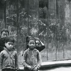 Four Yao (Iu Mien) boys stand in front of chalk drawings in a Yao village in the area of the town of Vang Vieng in Vientiane Province