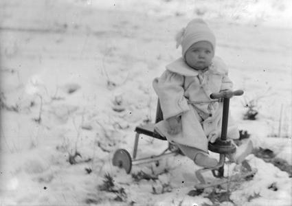 Child on trike in snow