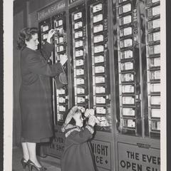 A woman and her young daughter use a vending machine