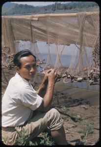 Young man fixing fish net