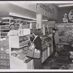 Shoppers select items from the prescription counter of a drugstore