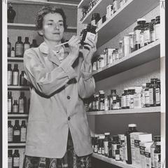 A pharmacist marks a bottled prescription