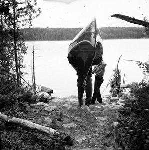 Bergere Kenney and Luna Leopold carrying canoe at Quetico