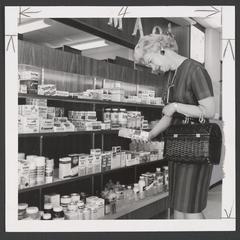 Woman makes a selection from a drugstore's cough and cold section