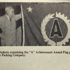 Harry Wedertz accepting the "A"Achievement Award flag