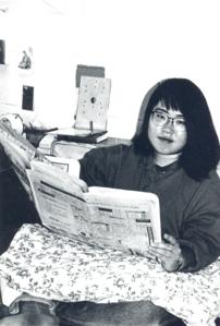 Student reading newspaper in dormitory