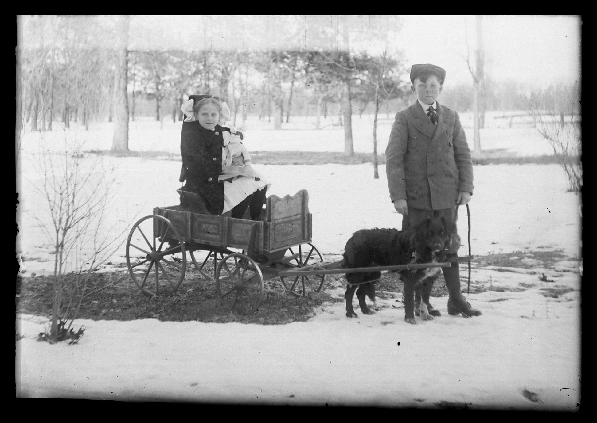 Children with dog pulling wagon