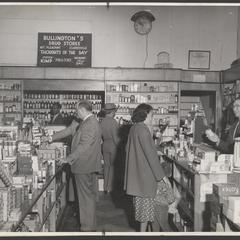 Customers shop at the prescription counter of a drugstore