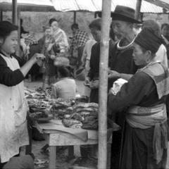 Vietnamese woman weighing meat for Hmong couple customers