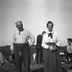 Unidentified man and woman standing near tent