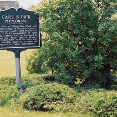 Carl S. Pick Memorial sign at Ridge Run Park with campus in background