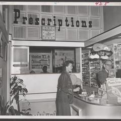Customers receive help at the prescription counter