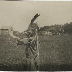Lorine shooting arrow dressed as American Indian