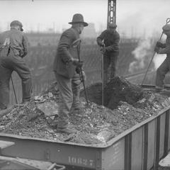 Men Unloading Iron Ore from Rail Car into Ore Dock