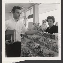 A young man selects candy at a drugstore counter