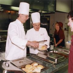Chancellor Mark L. Perkins serving food in cafeteria line