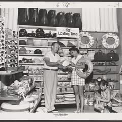 A woman and young girl view items in a drugstore vacation display