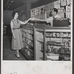 A pharmacist and his wife pose at the prescription counter