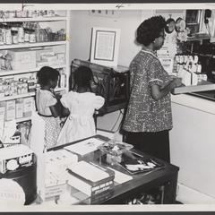 A woman and her daughters wait at the prescription counter of a drugstore