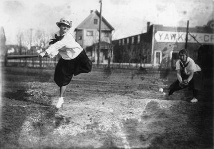 Woman swinging bat in physical education baseball game