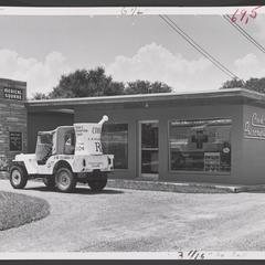 A Jeep with an oversized promotional mortar and pestle sits outside Cook's Prescription Shop