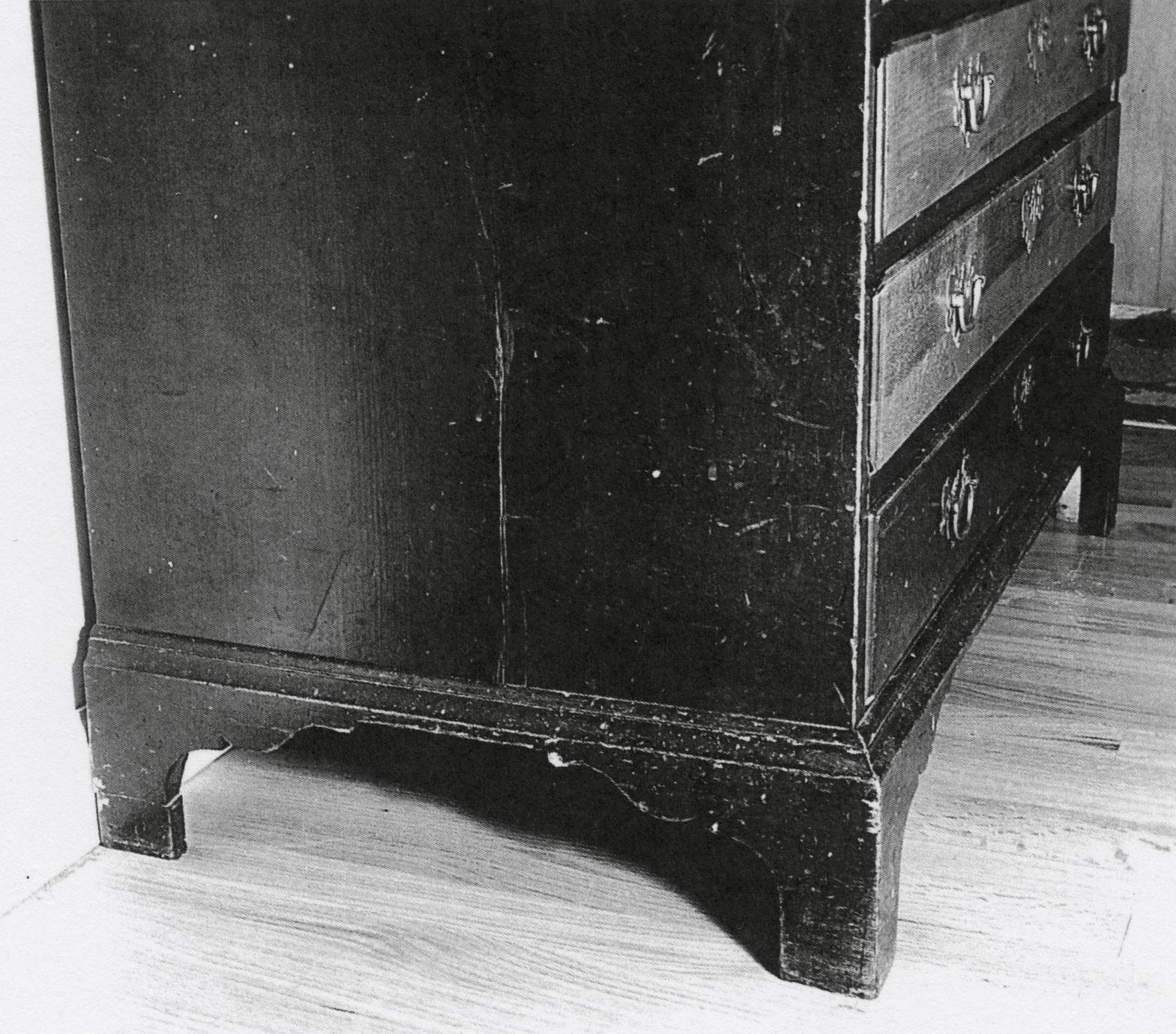 Black and white photograph of a desk and bookcase.
