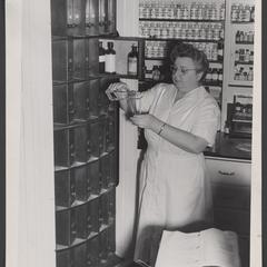 Woman pours liquid from a bottle from a rotating cabinet
