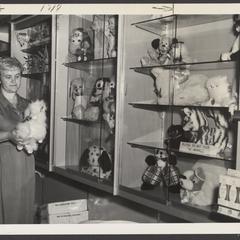A woman holds a stuffed animal at a toy display