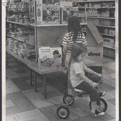 Two young girls examine toys in a drugstore toy department