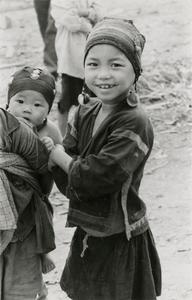 An Akha girl stands next to her brother with infant in the village of Phate in Houa Khong Province