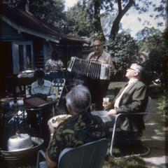 Ed Piller plays concertina at backyard party