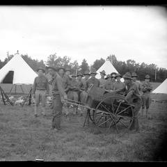 Soldiers with wagon, in front of military tent camp