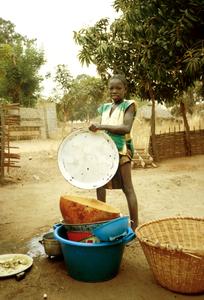 Young Girl Washing Dishes in Typical Fashion in Goudomp