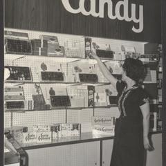 A woman selects candy at a drugstore