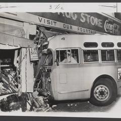 A bus sits in the front window of a drugstore after hitting it