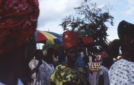 Woman with red headdress at procession after installation of Oba Odo