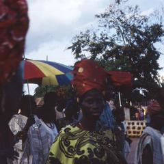 Woman with red headdress at procession after installation of Oba Odo