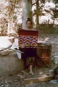 Kalom woman displays a newly woven skirt in Houa Khong Province
