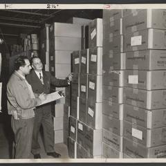 Two men check emergency supplies in a warehouse