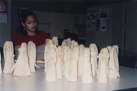 Female student making cornhusk dolls