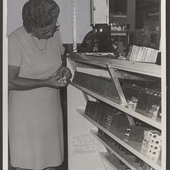 A woman stocks candy shelves in a drugstore
