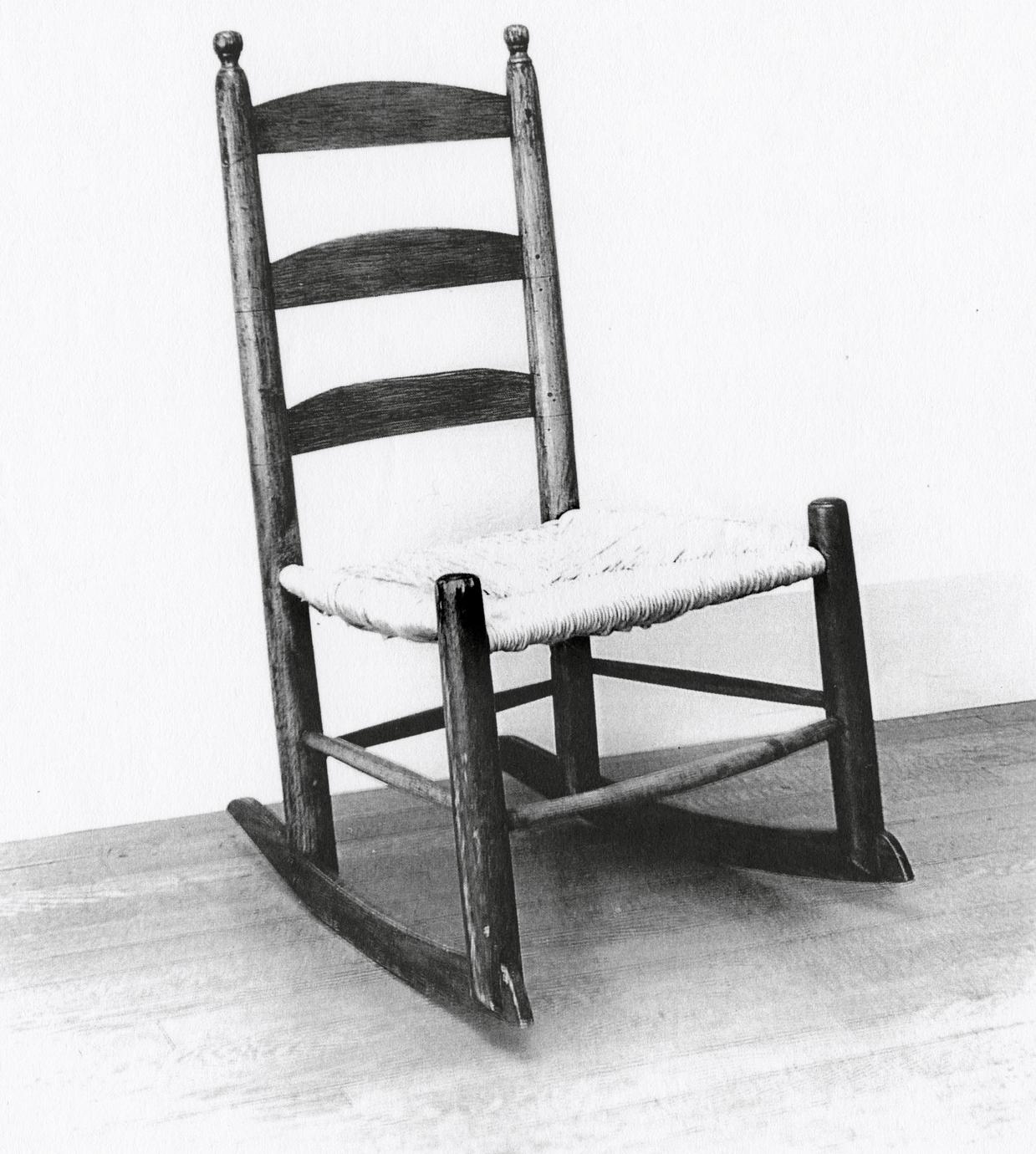 Black and white photograph of a slat-back chair with rockers.