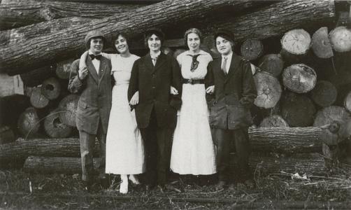 Five girls in front of some logs