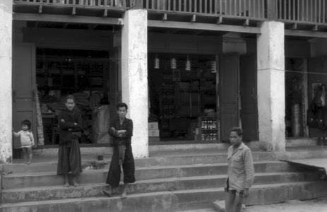 Akha tribesmen on steps of Chinese shops