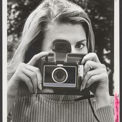 A woman holds a camera up to take a picture
